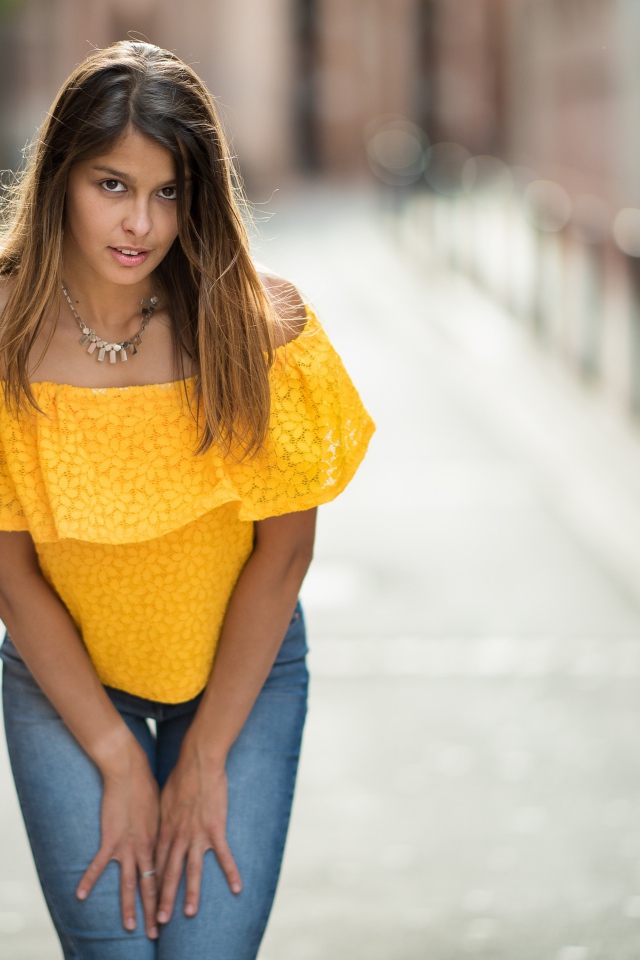 Девушка в джинсах стоит на улице 