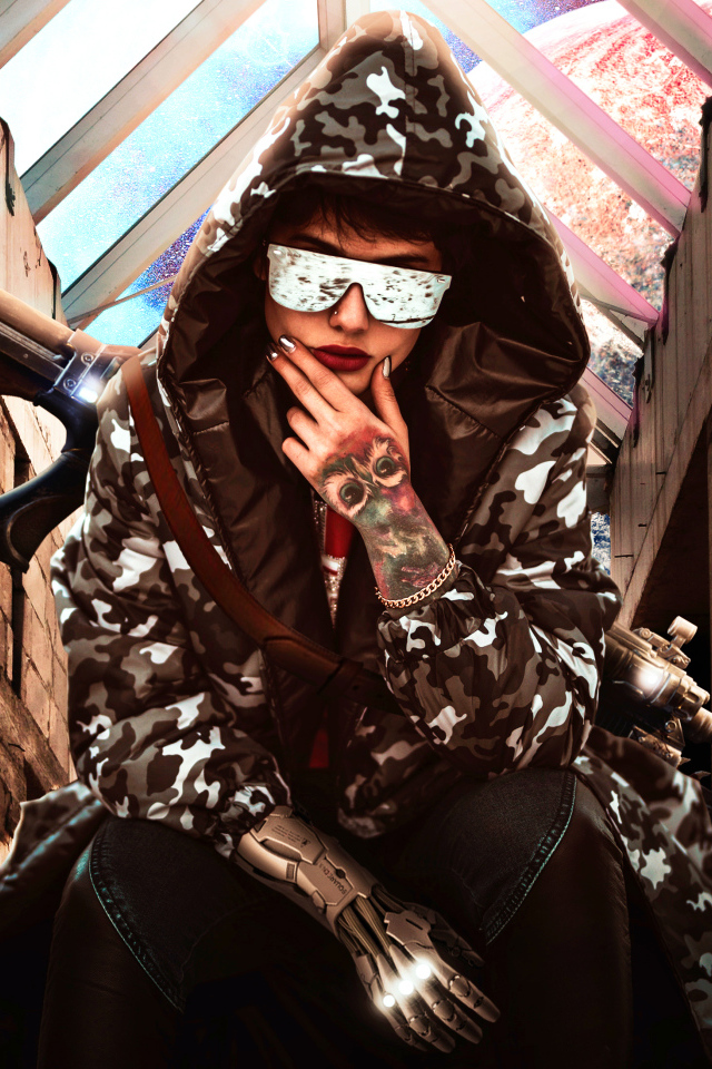 Девушка с оружием в худи и очках 