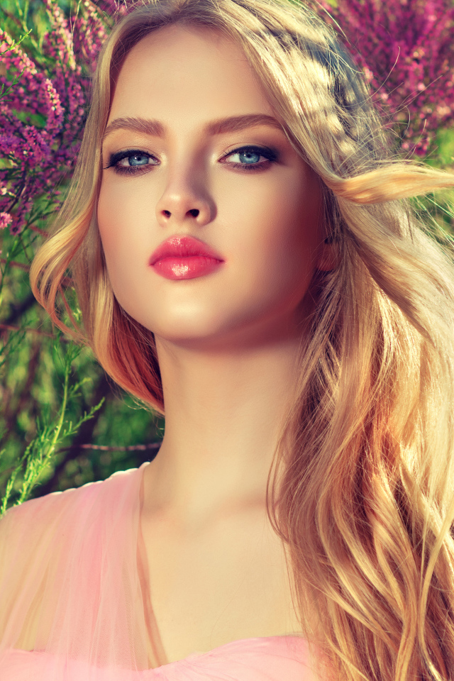 Девушка с красивыми голубыми глазами у цветущего дерева