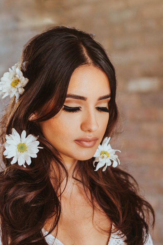 Девушка с закрытыми глазами с ромашками в волосах 