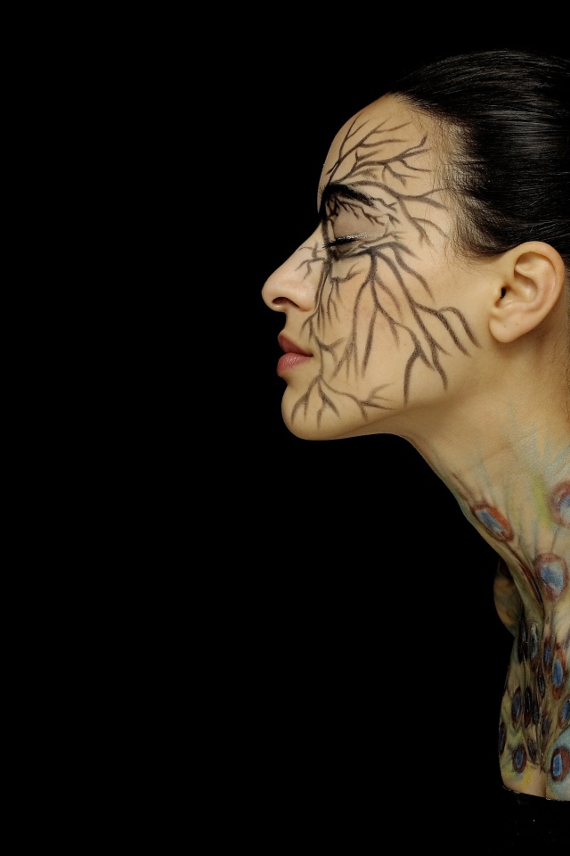 Девушка с рисунками на теле на черном фоне