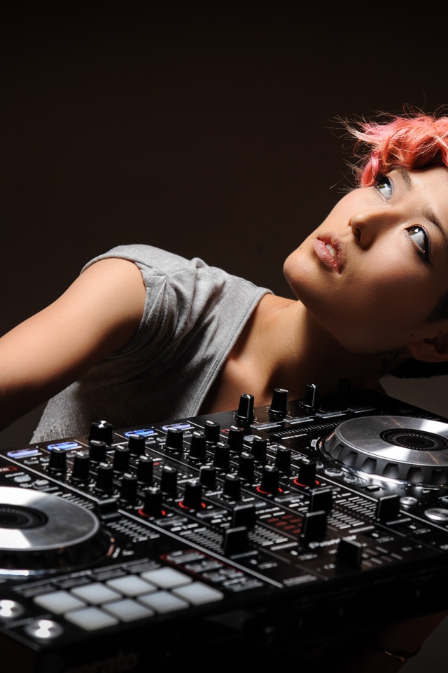 Девушка с розовой челкой с диджейским пультом в руках