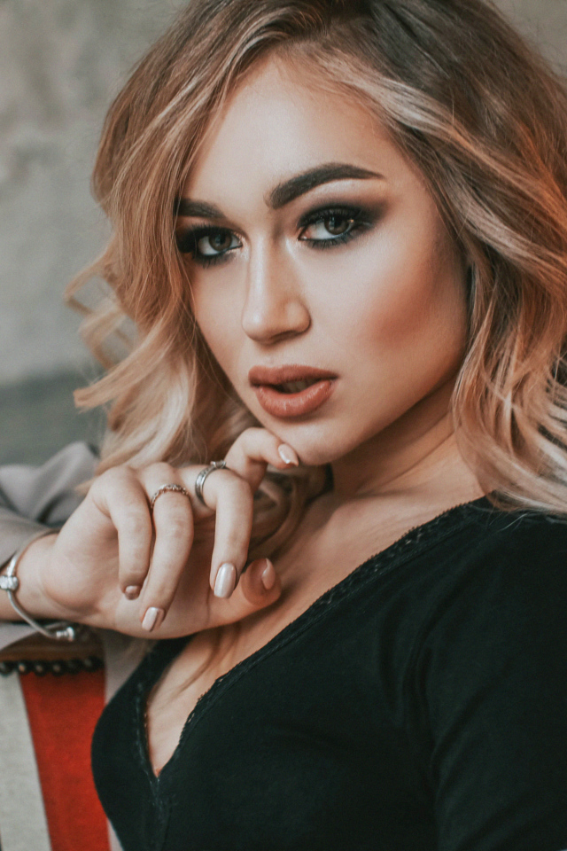 Горячая девушка с макияжем сидит на стуле