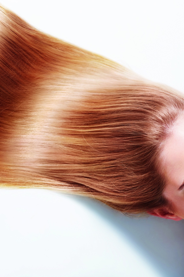 Длинноволосая шатенка с закрытыми глазами на белом фоне