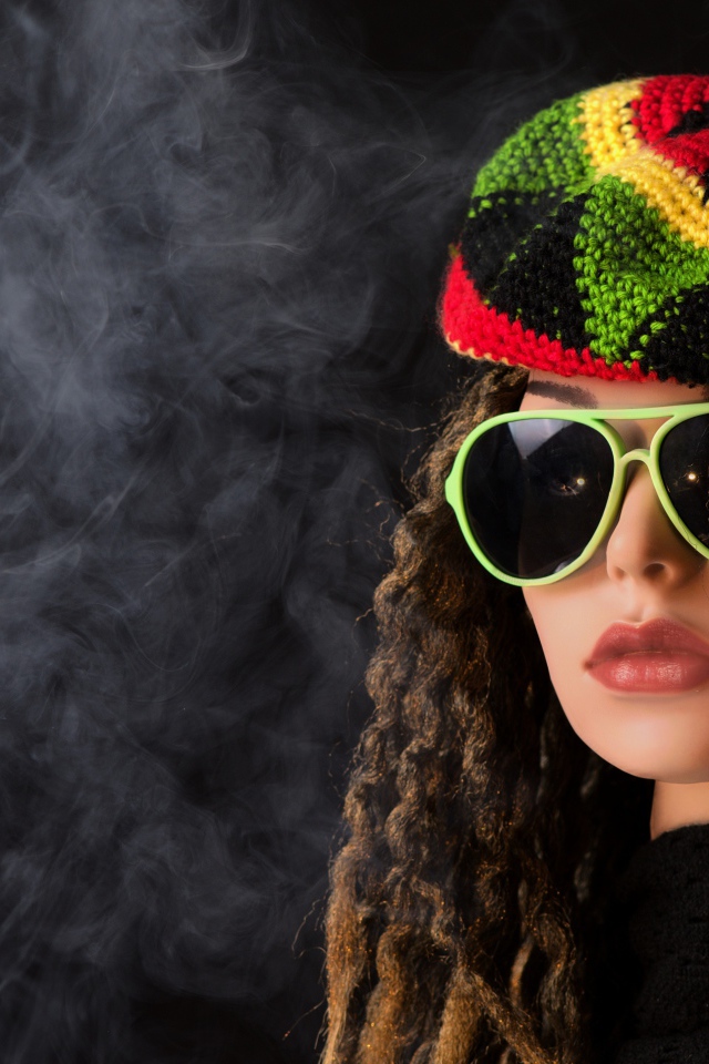 Девушка растаманка в черных очках в дыму