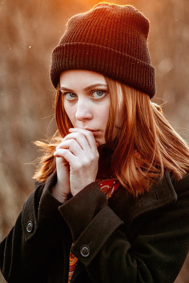Рыжеволосая девушка в черной шапке в пальто 