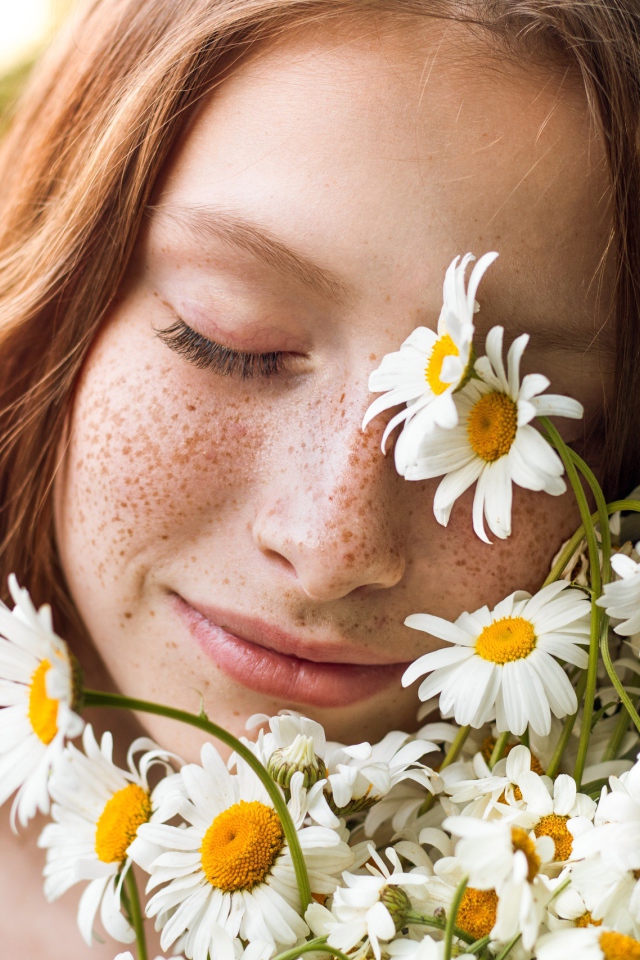 Рыжеволосая девушка с букетом ромашек