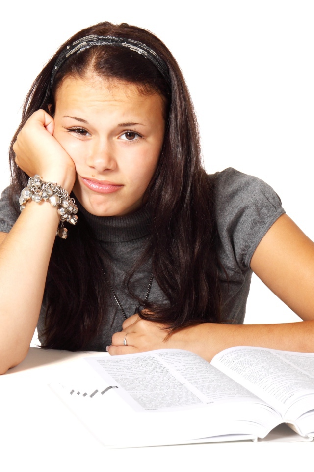 Грустная девушка читает книгу на белом фоне