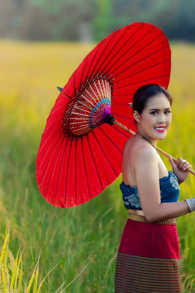 Улыбающаяся девушка азиатка с красным зонтом