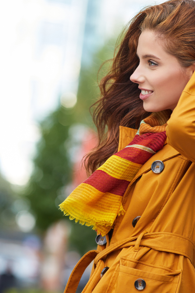 Улыбающаяся девушка в оранжевом пальто 