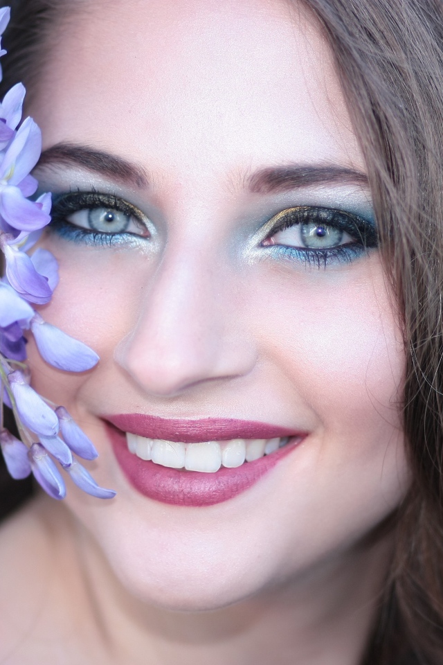 Улыбающаяся девушка с цветами глицинии