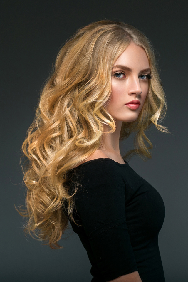 Стильная голубоглазая длинноволосая девушка в черном наряде