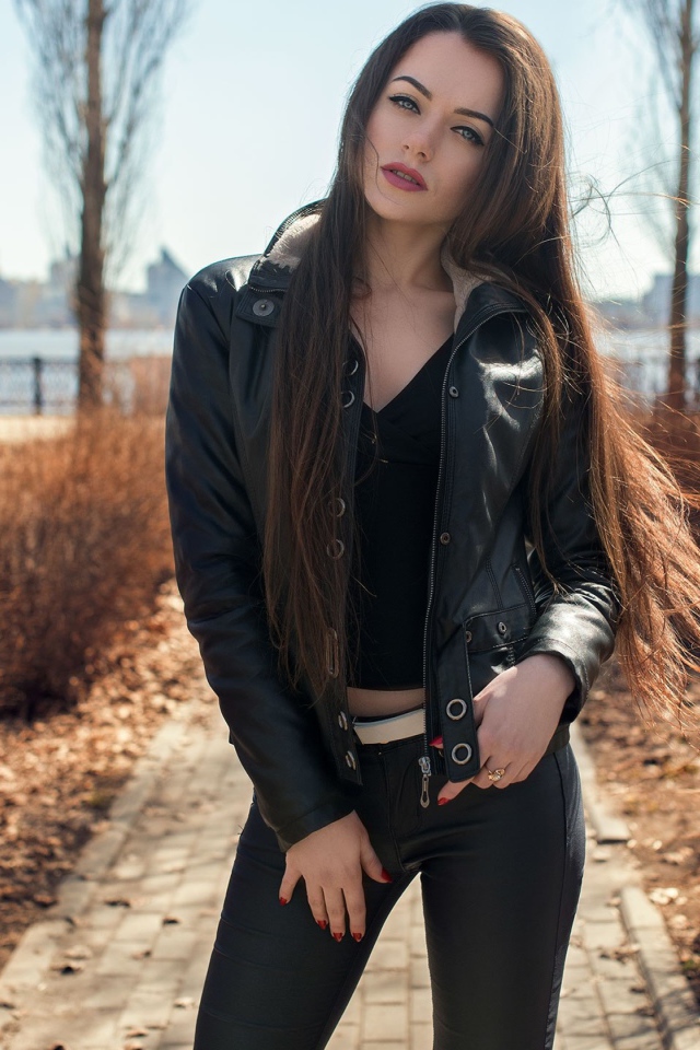 Стильная девушка в черной куртке в парке 