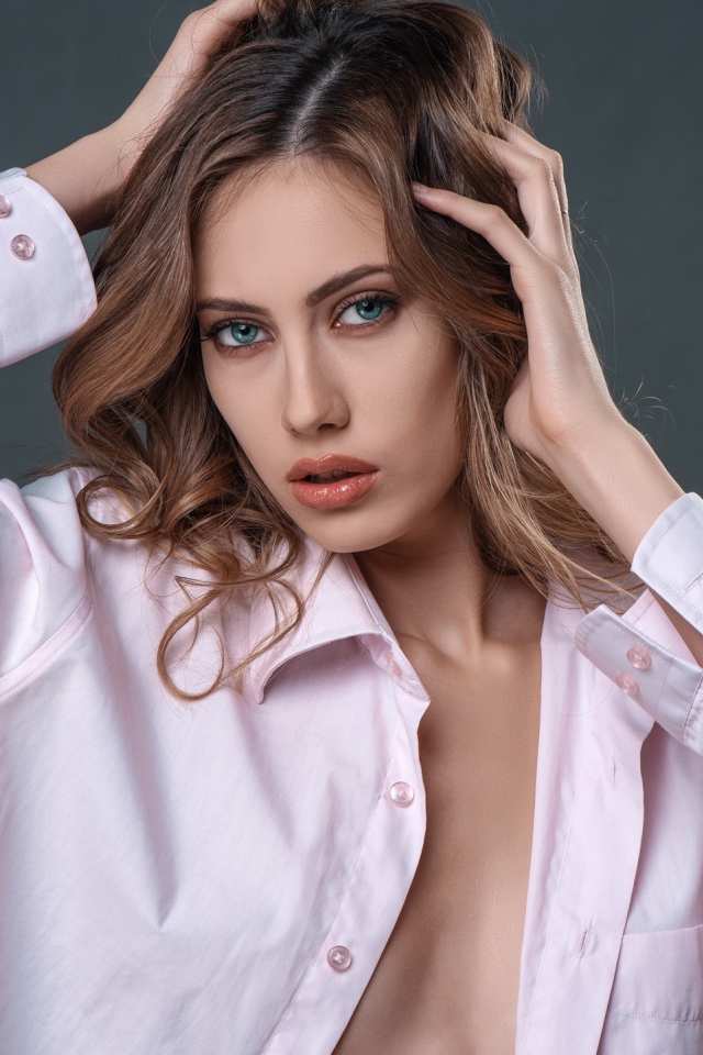 Стильная девушка в розовой рубашке на сером фоне