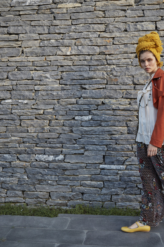 Стильная девушка на фоне стены 