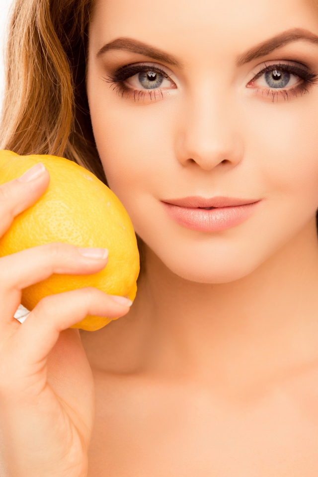 Нежная голубоглазая девушка с лимоном в руке