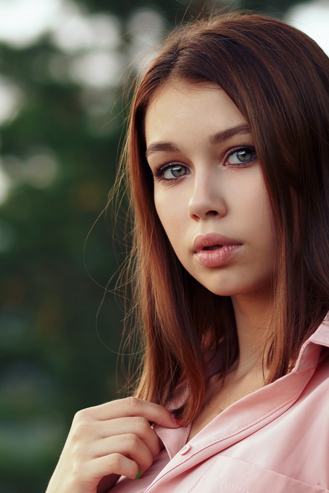 Нежная девушка стоит у дерева