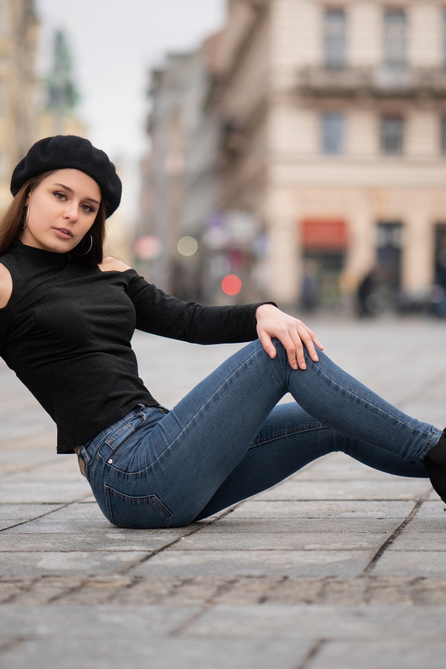 Девушка в черном берете лежит на дороге 