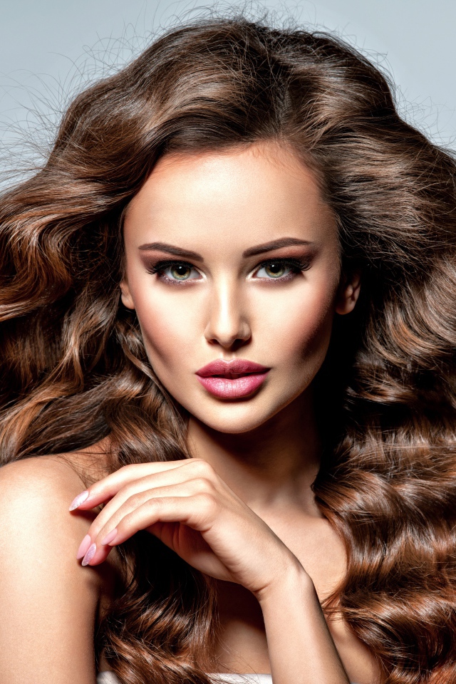 Девушка с красивыми длинными волосами на сером фоне