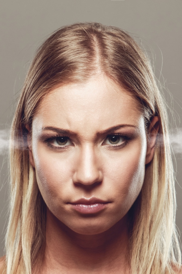 Дым из ушей у девушки блондинки на сером фоне