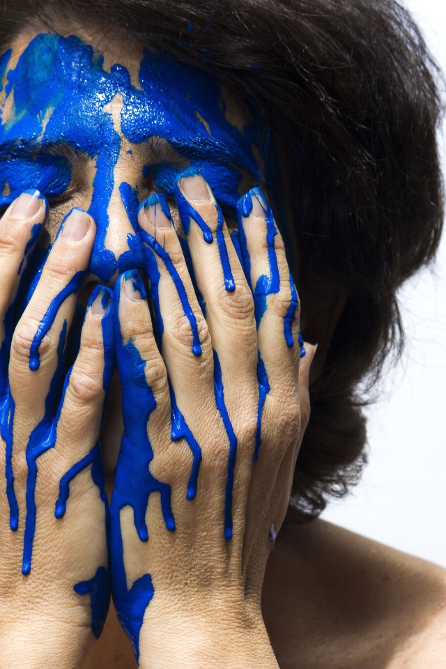 Лицо и руки женщины в синей краске