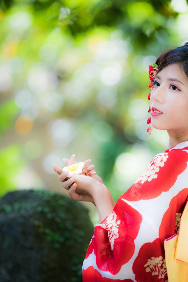 Молодая девушка азиатка в кимоно с цветами в волосах 