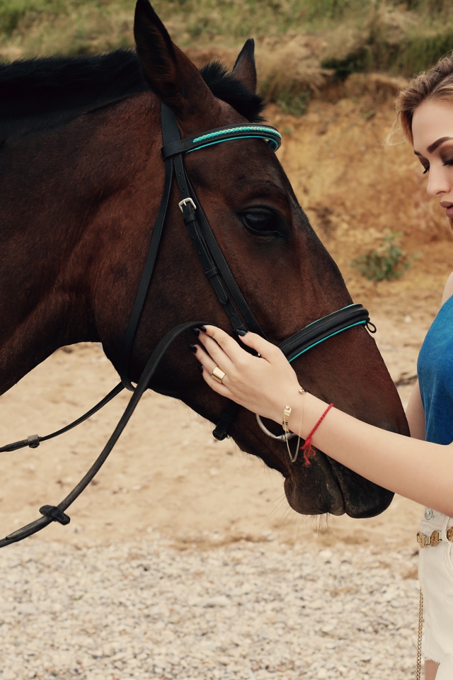 Молодая девушка блондинка с коричневой лошадью 