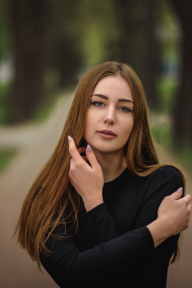 Молодая девушка в черном наряде в парке