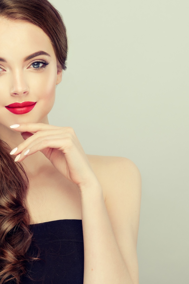 Молодая девушка с красивыми волосами на сером фоне