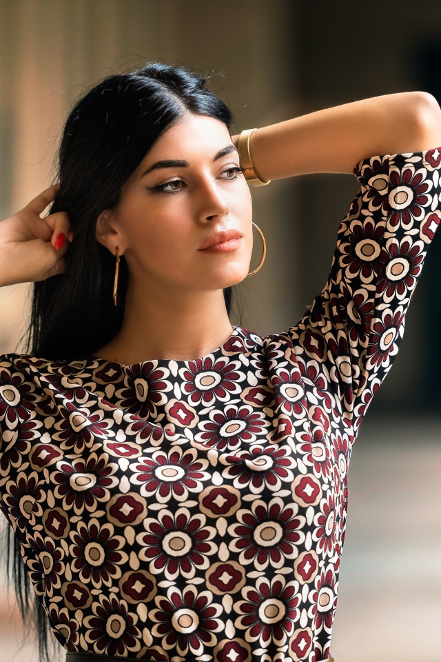 Молодая длинноволосая шатенка с руками в волосах