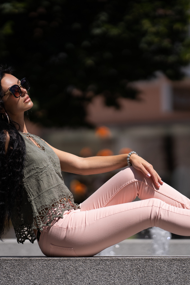 Молодая длинноволосая брюнетка в розовых джинсах