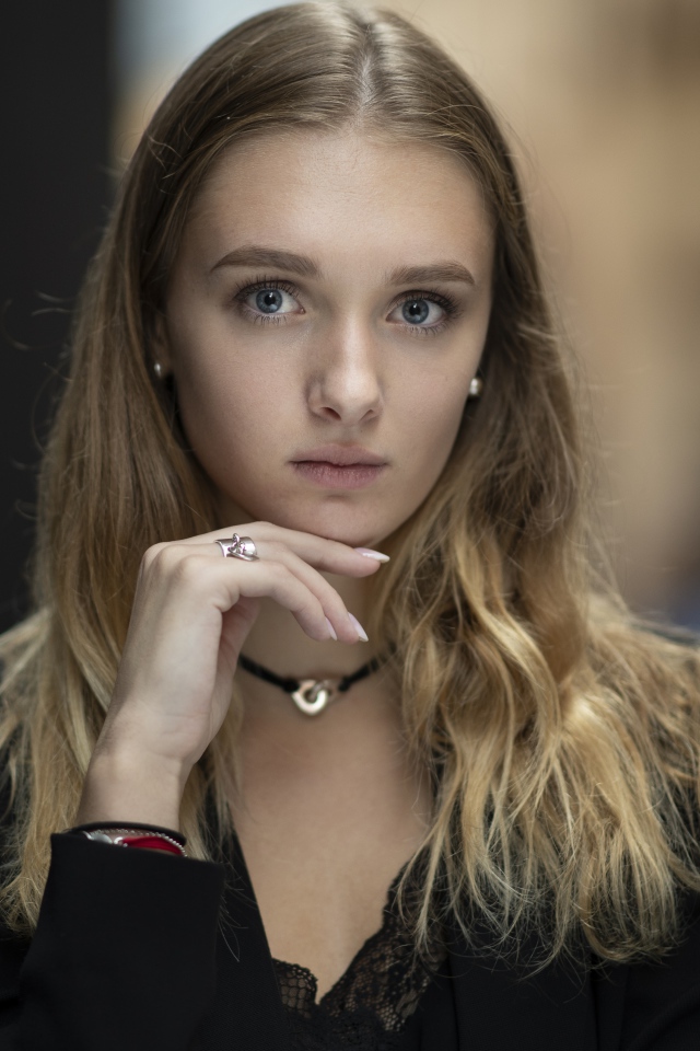 Молодая нежная голубоглазая девушка с рукой у лица