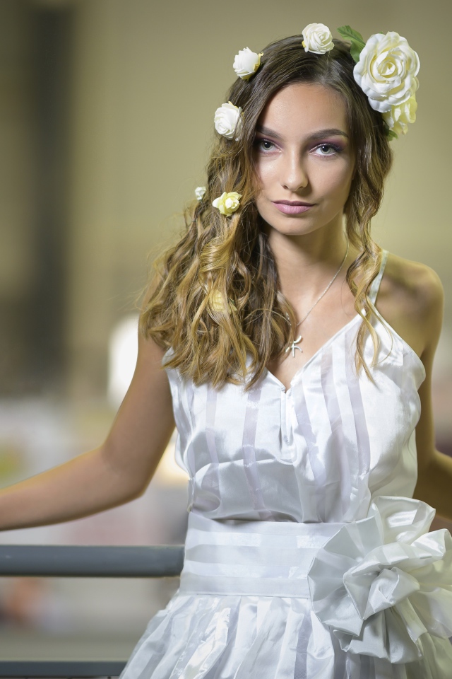 Красивая девушка в белом платье с цветами в волосах 