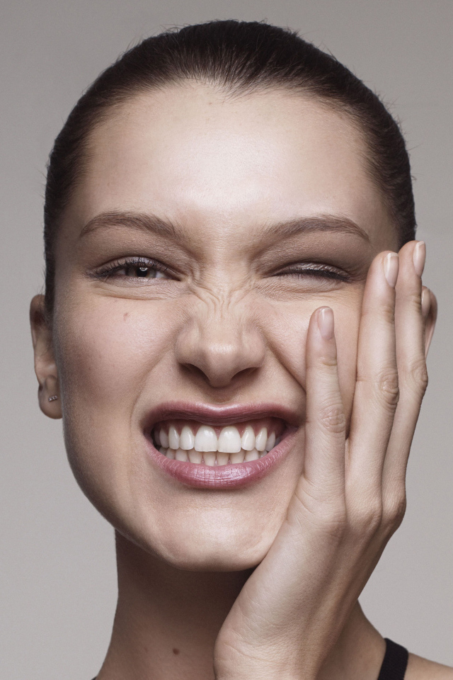 Модель Белла Хадид корчит гримасы на сером фоне