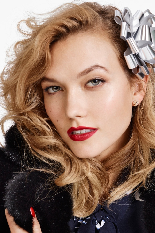 Модель Карли Клосс в черной шубе на белом фоне