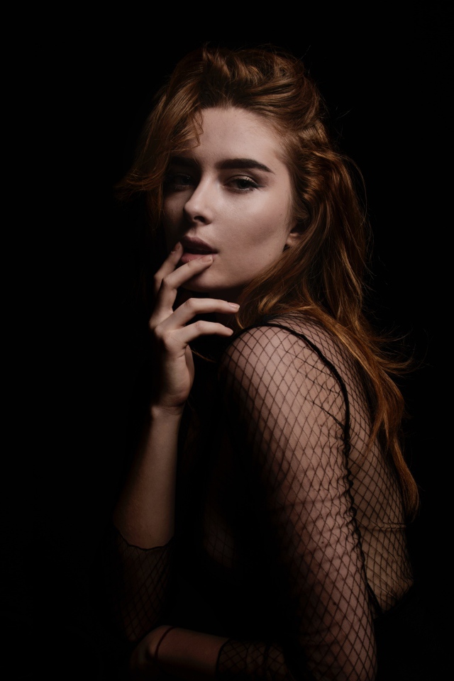 Red-haired girl model on a black background
