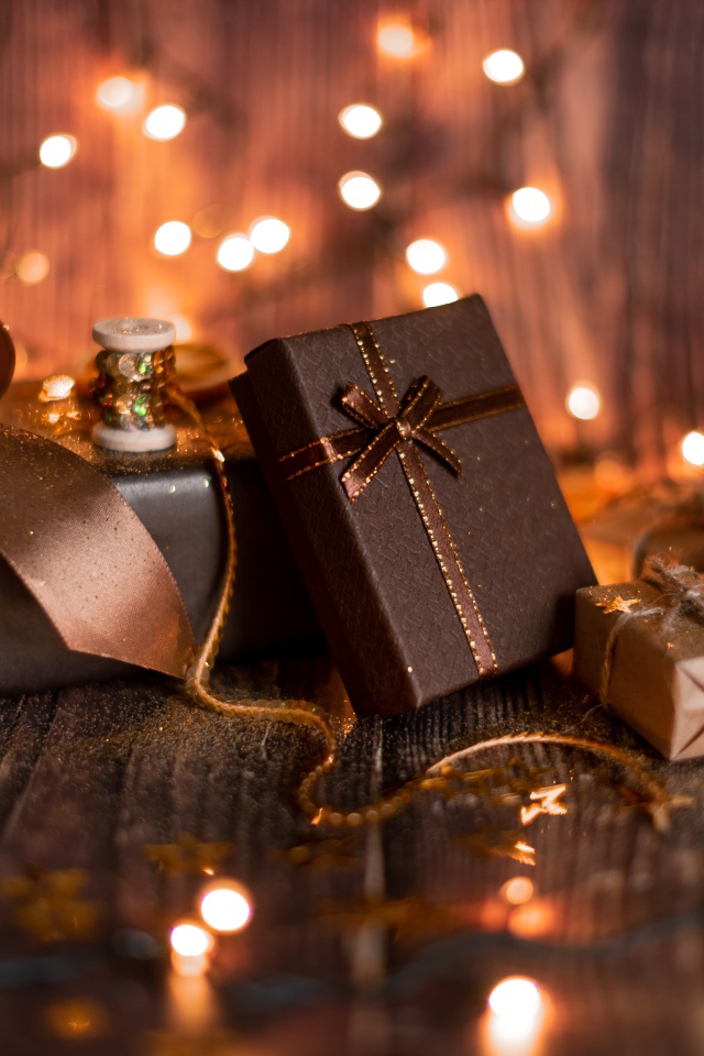 Много подарков на деревянном фоне с гирляндой