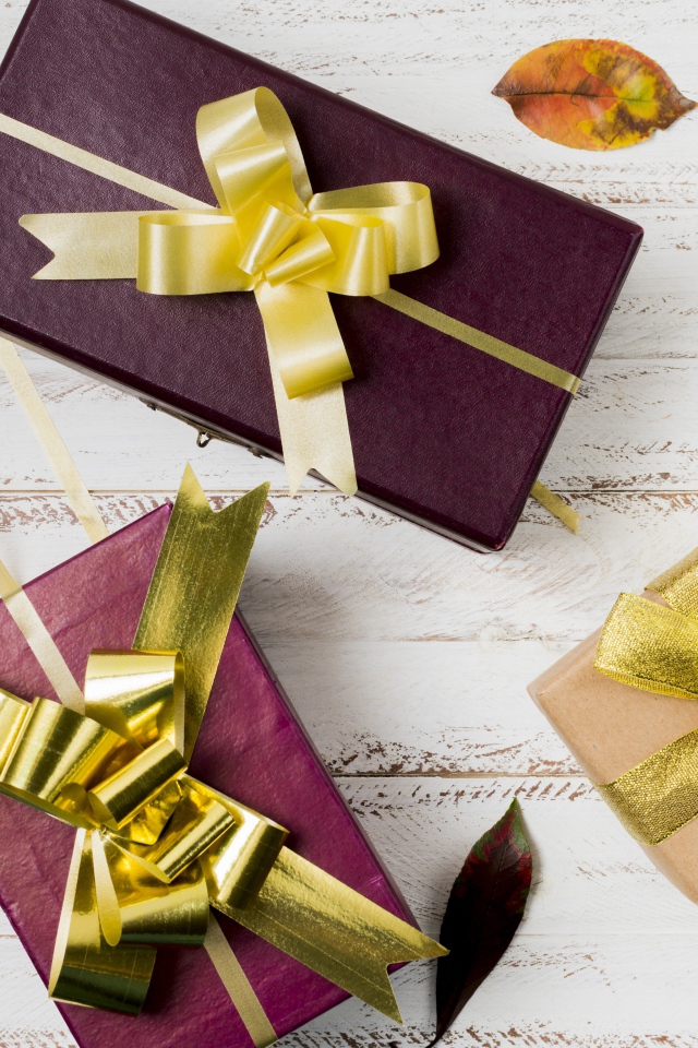 Три подарочные коробки с бантами на столе