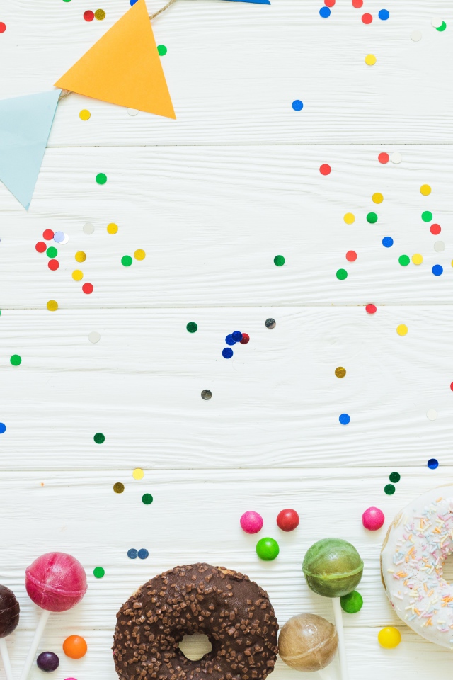 Пончики с глазурью и конфеты на праздничном фоне