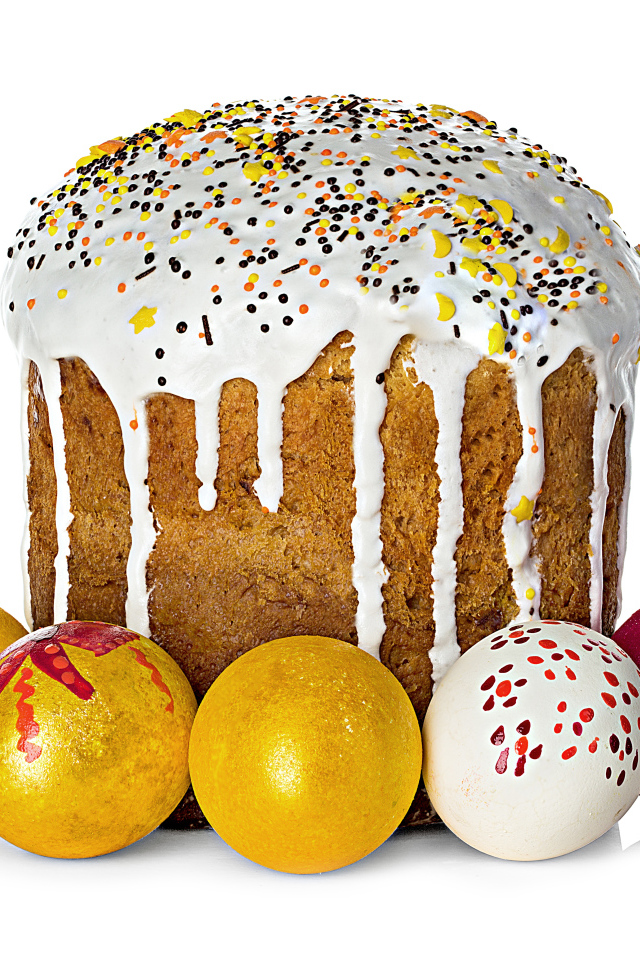 Красивый большой кулич с крашеными яйцами на белом фоне на Пасху