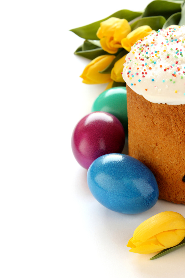 Красивый праздничный кулич с желтыми тюльпанами и крашеными яйцами на белом фоне к Пасхе