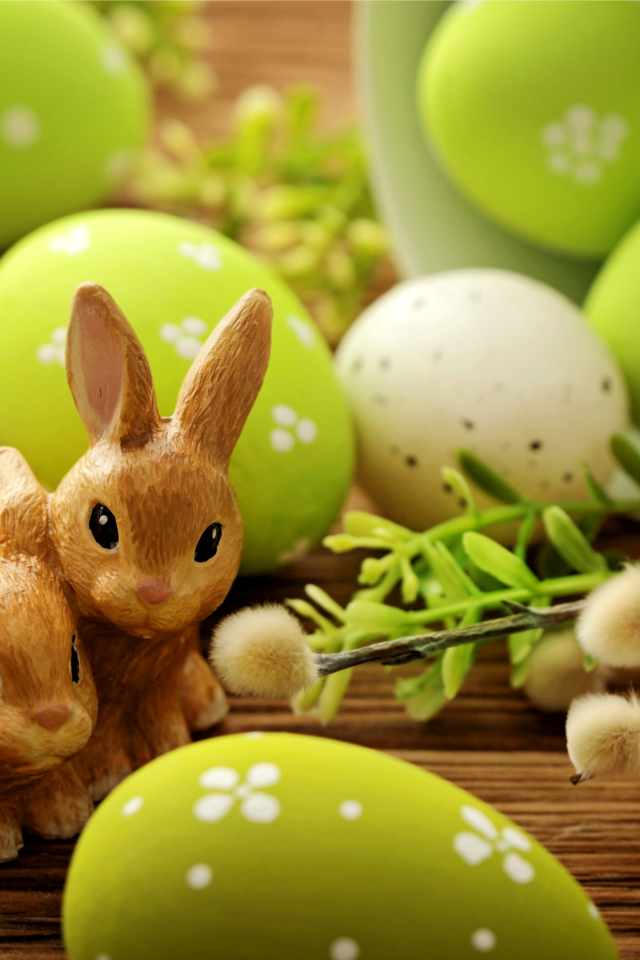 Крашеные яйца с веткой вербы и фигурками кроликов на праздник Пасха