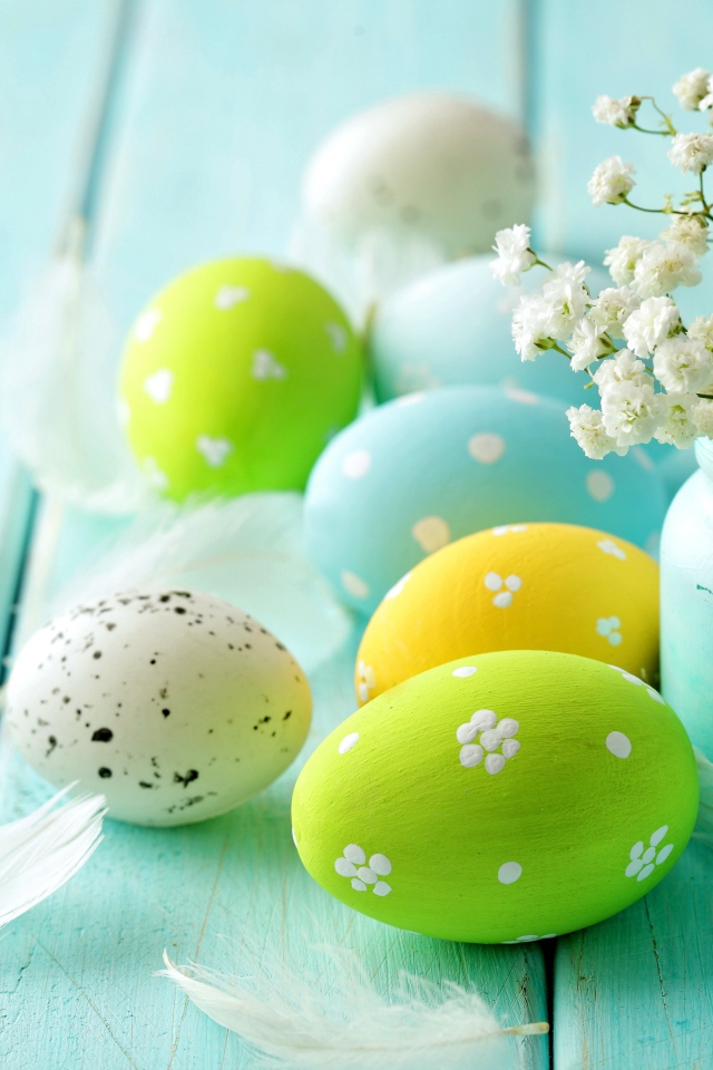 Крашеные яйца с цветами на голубом столе 