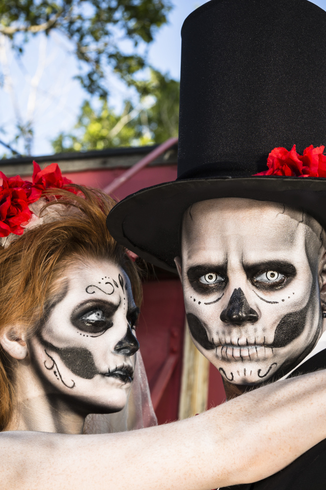 Пара жених и невеста с масками с грима на лице на Хэллоуин 