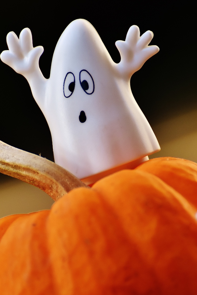 Игрушечные призраки на тыкве на Хэллоуин 