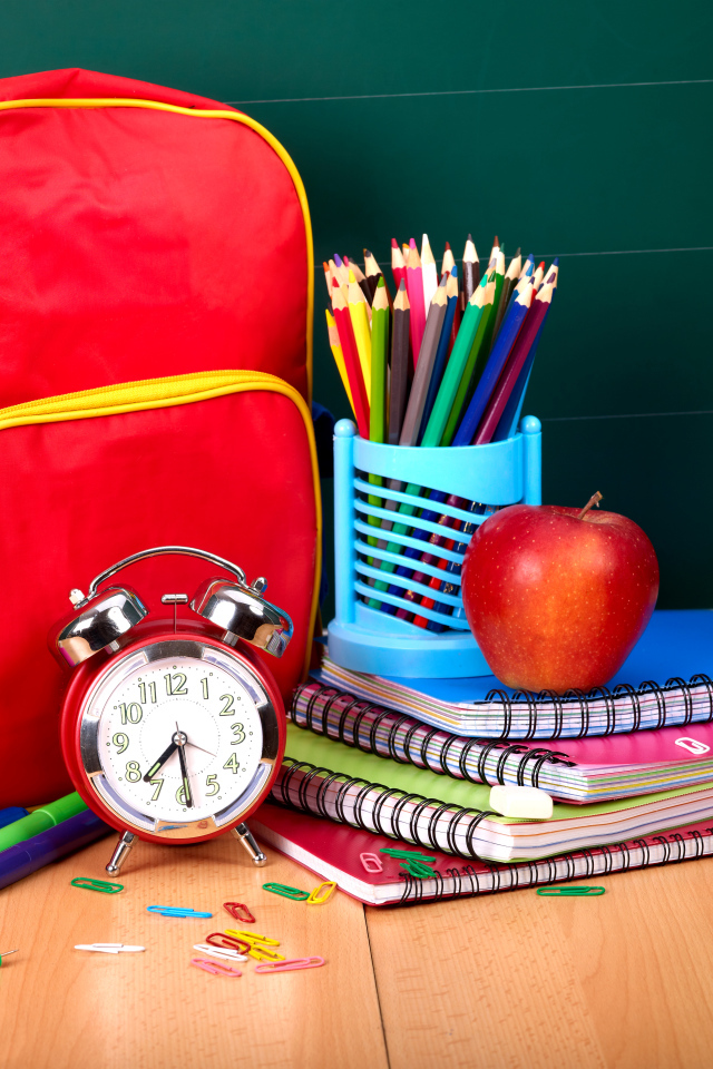 Рюкзак, тетради, карандаши, будильник и яблоко на День знаний 1 сентября