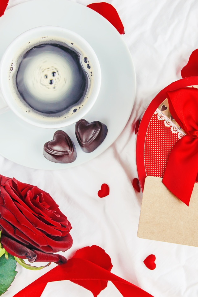 Чашка кофе на столе с коробкой в форме сердца и красной розой для любимой