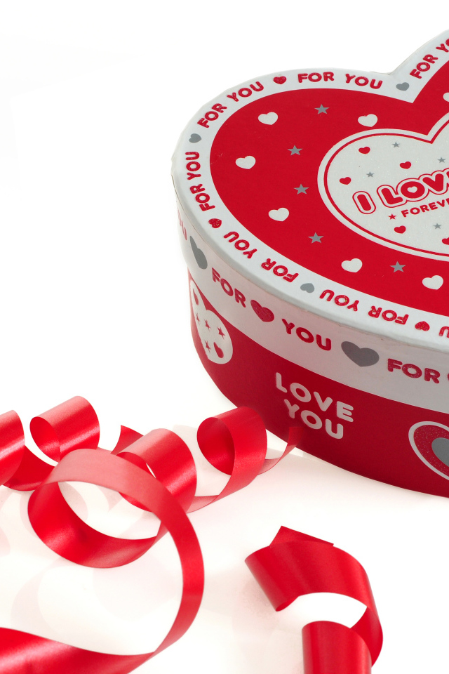 Красивая коробка в форме сердца на белом фоне с красной лентой