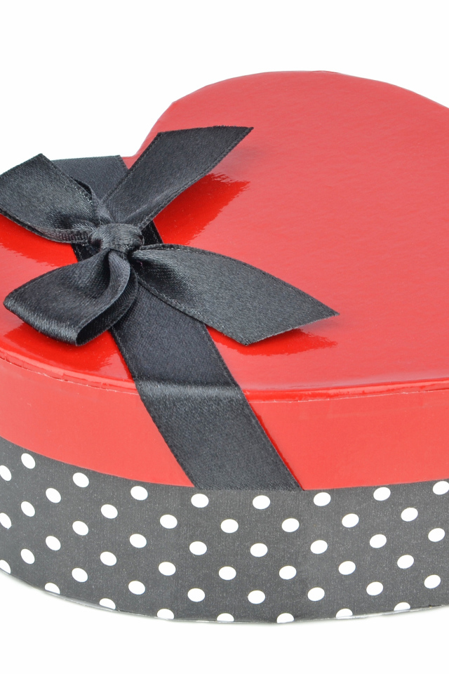 Красивая коробка в форме сердца с черным бантом на белом фоне