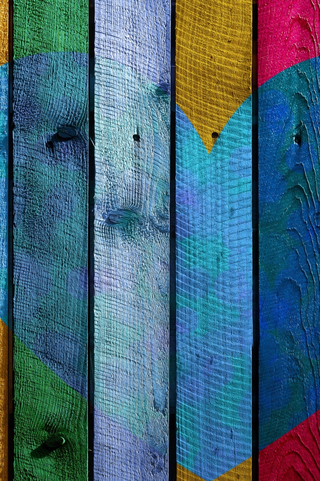 Голубое сердце нарисовано на разноцветном заборе